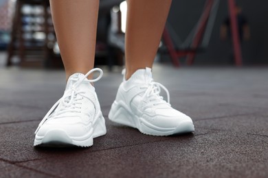 Photo of Woman wearing pair of stylish sneakers outdoors, closeup