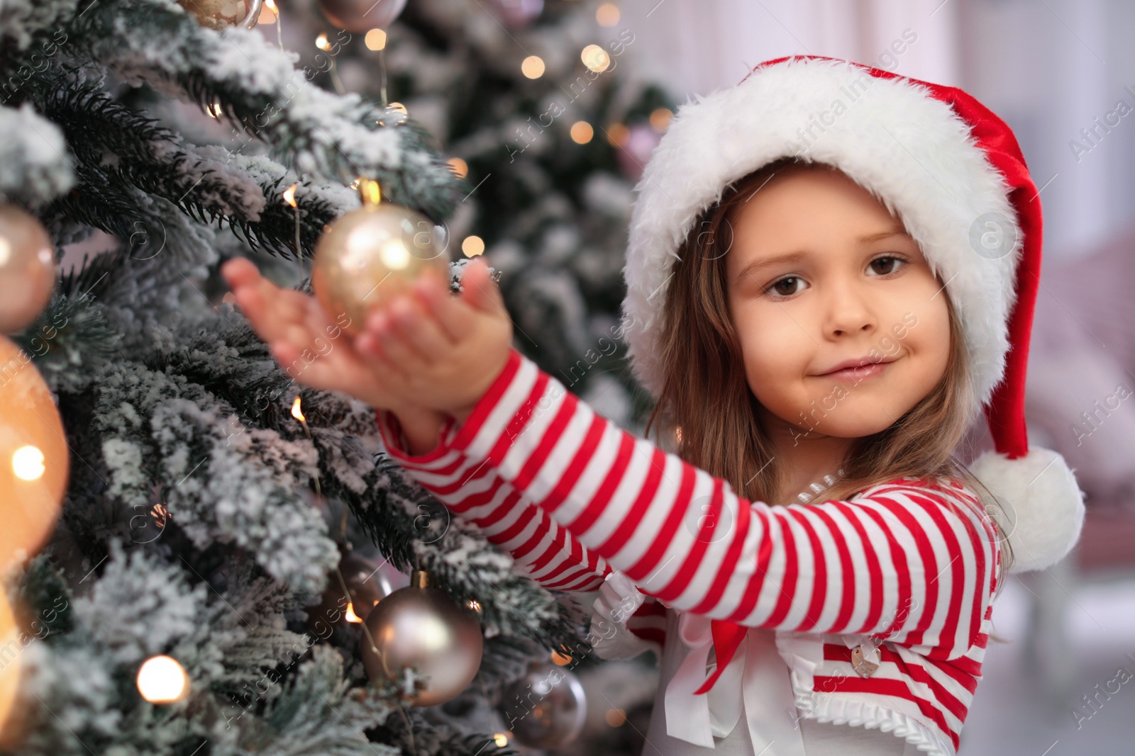 Photo of Cute little child near Christmas tree at home