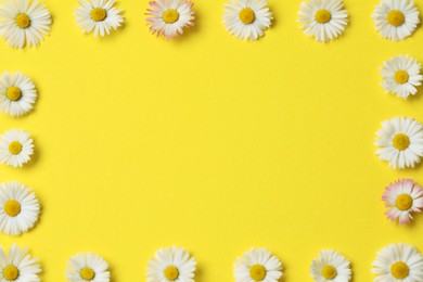 Photo of Frame of daisy flowers on yellow background, flat lay. Space for text