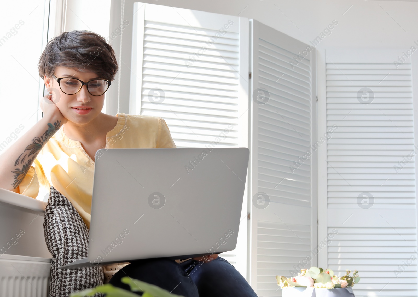 Photo of Young woman working with laptop at home