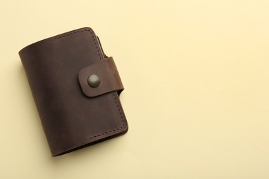 Stylish leather card holder on beige background, top view. Space for text