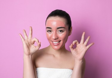 Photo of Woman with pomegranate face mask showing Ok on pink background