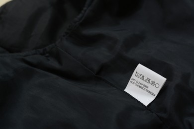 Photo of Clothing label on black garment, space for text