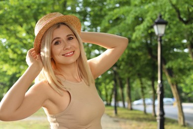 Portrait of beautiful woman in straw hat outdoors on sunny day