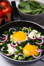 Tasty green Shakshouka served on white wooden table, closeup