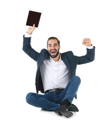 Emotional businessman in office wear with tablet celebrating victory on white background