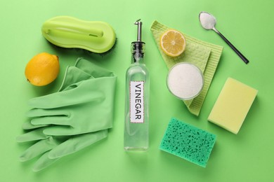 Photo of Eco friendly natural cleaners. Flat lay composition with bottle of vinegar on green background