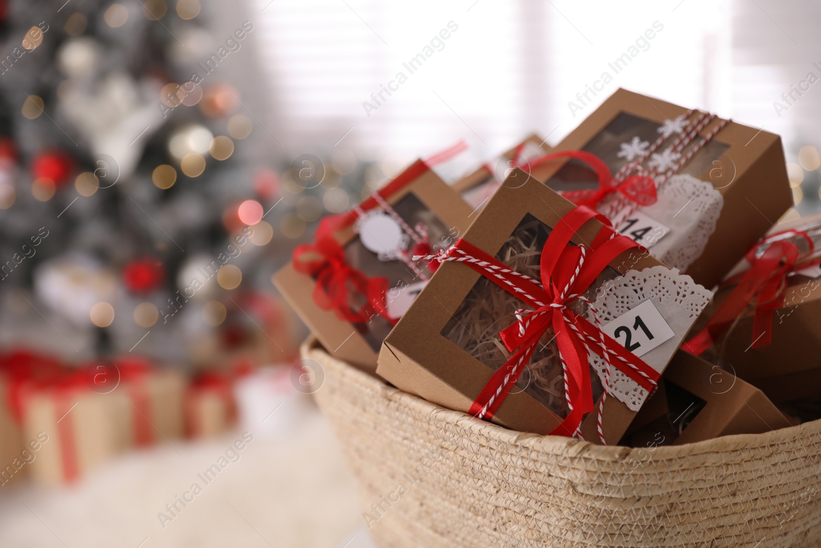 Photo of Basket full of gift boxes for Christmas advent calendar in room, space for text