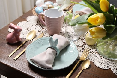 Photo of Festive table setting with napkin ring in shape of bunny ears, closeup. Easter celebration