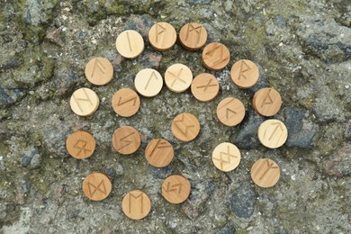 Photo of Many wooden runes on stone outdoors, flat lay
