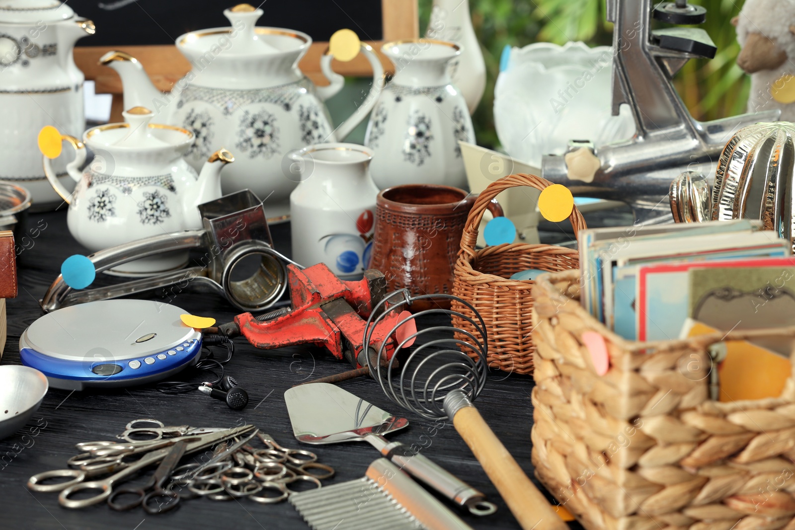 Photo of Many different stuff on black wooden table. Garage sale