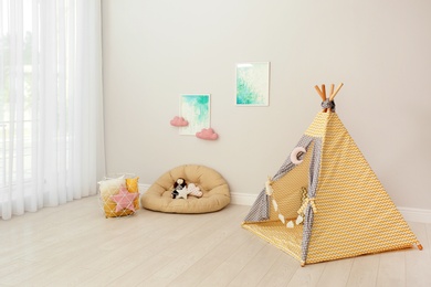 Photo of Modern nursery room interior with play tent for kids