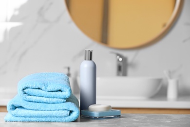 Folded towels and toiletries on marble table in bathroom, space for text