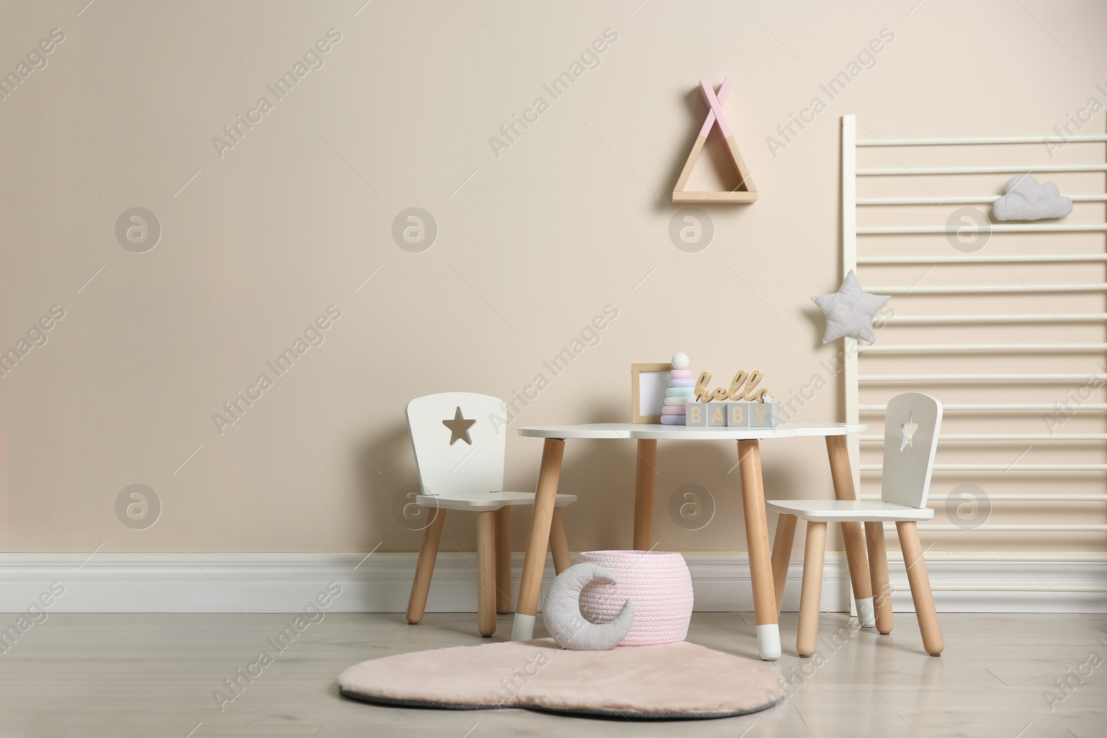 Photo of Baby room interior with stylish table, chairs and toys