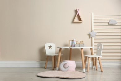 Photo of Baby room interior with stylish table, chairs and toys