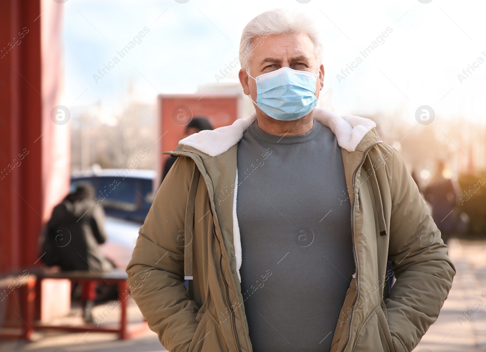 Photo of Senior man with medical mask on city street. Virus protection
