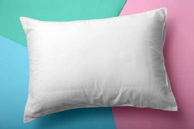 Soft bed pillow on color background, top view