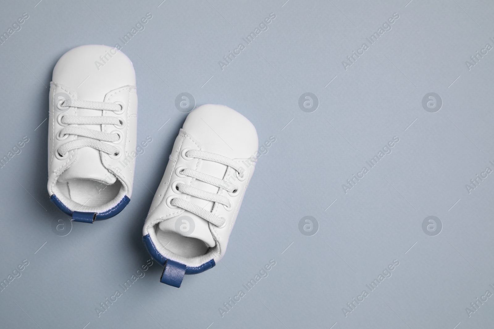 Photo of Cute baby shoes on grey background, flat lay. Space for text