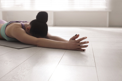 Young woman practicing relaxation pose in yoga studio