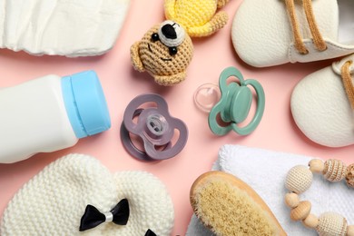Photo of Flat lay composition with pacifiers and other baby stuff on pink background
