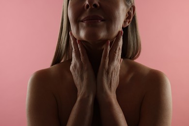 Photo of Mature woman with healthy skin on pink background, closeup