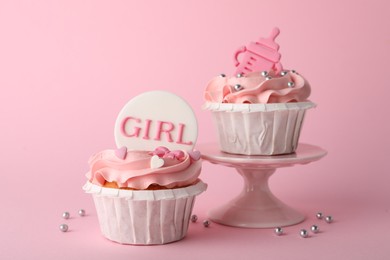 Photo of Baby shower cupcakes with toppers on pink background