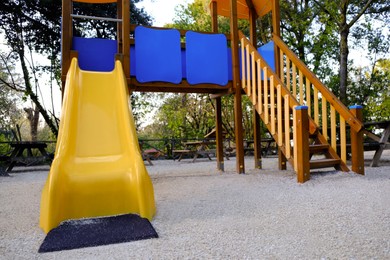 Photo of Empty playground with beautiful slide and trees in park