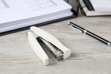 Photo of Stapler on wooden table, closeup. Office stationery