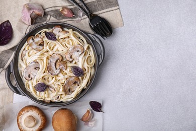 Photo of Delicious pasta with mushrooms served on grey table, flat lay. Space for text