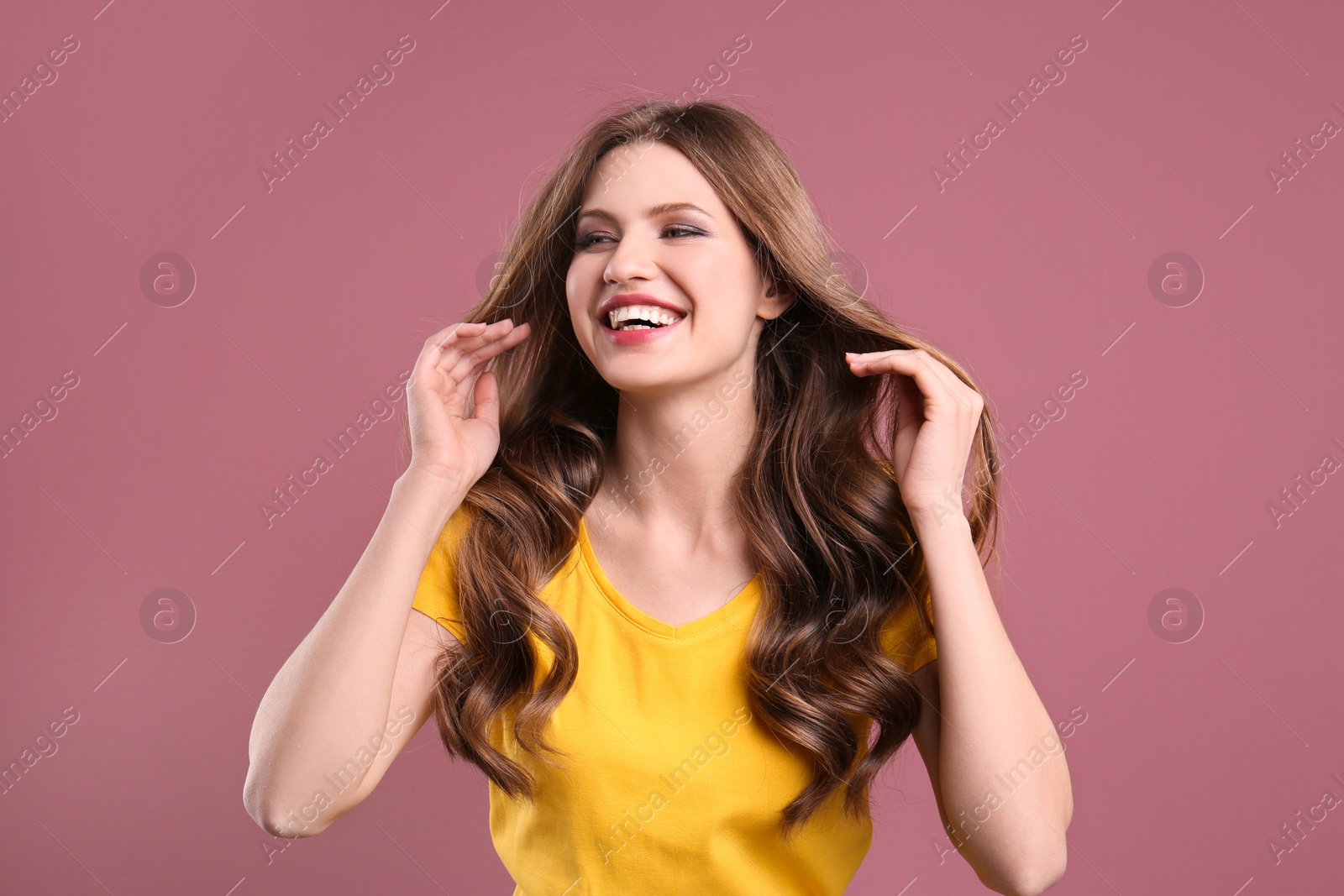 Photo of Portrait of young woman with long beautiful hair on color background