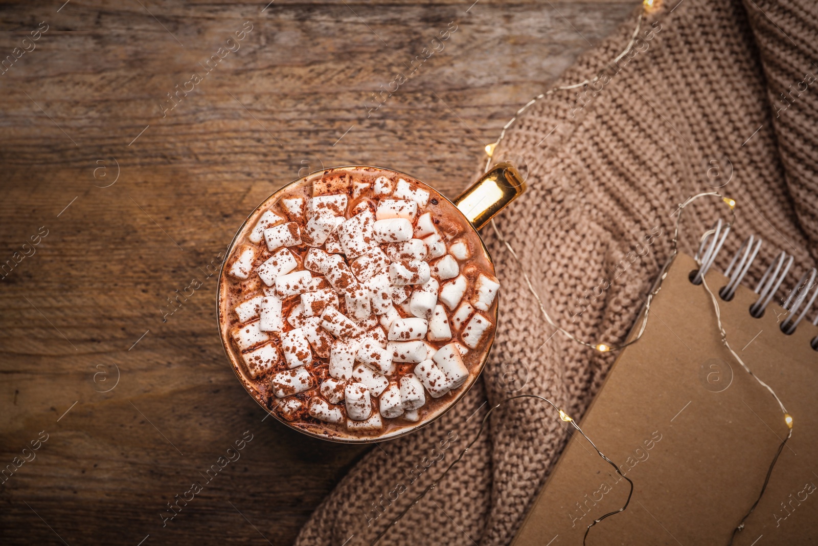 Photo of Cup of delicious hot cocoa with marshmallows on wooden table, flat lay