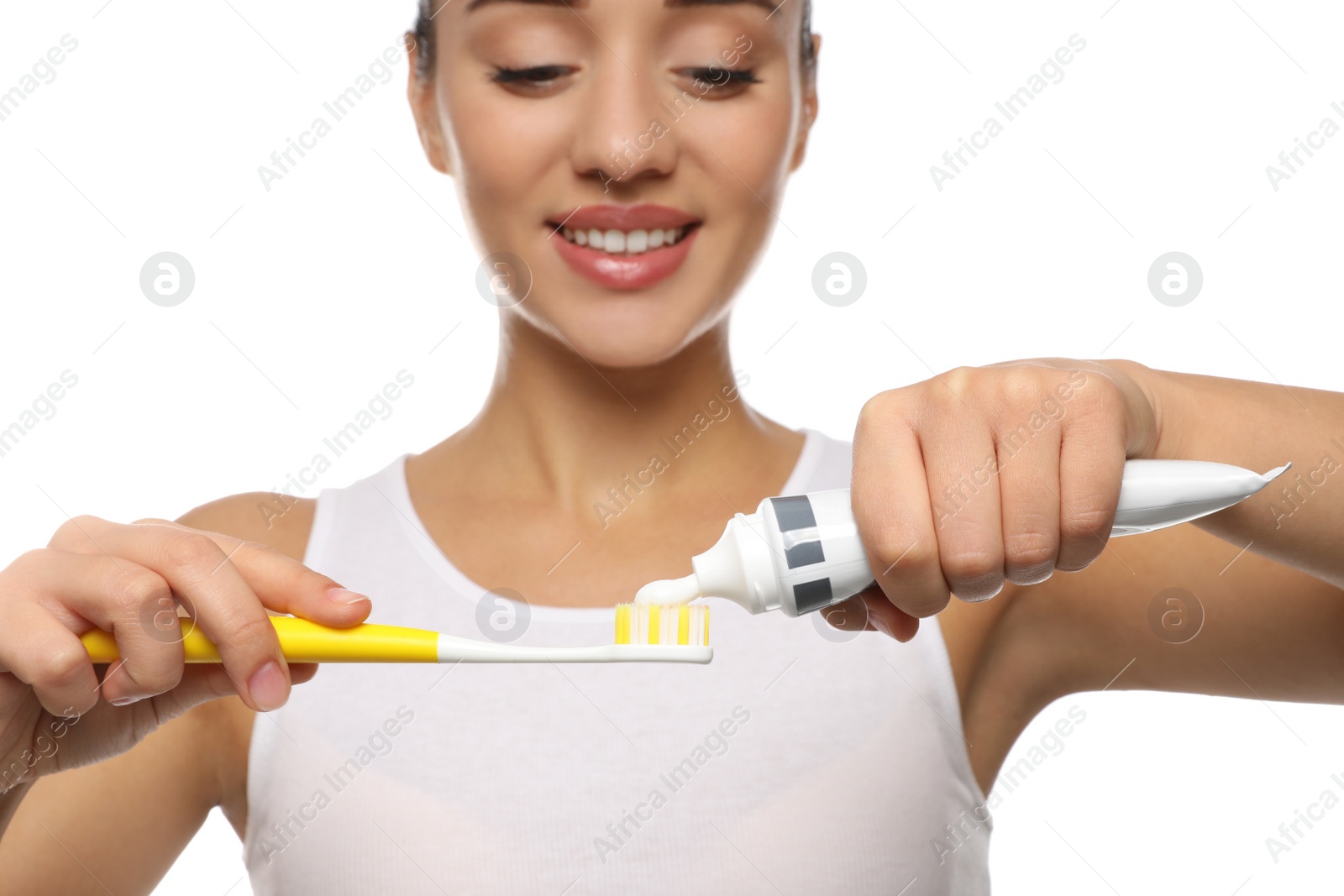 Photo of Woman applying toothpaste on brush against white background