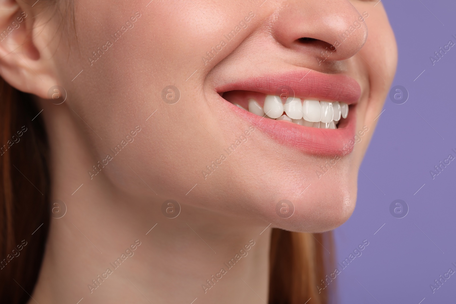 Photo of Woman with clean teeth smiling on violet background, closeup