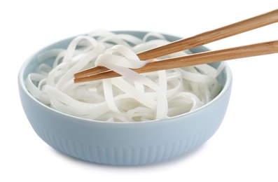 Chopsticks with tasty cooked rice noodles over bowl isolated on white