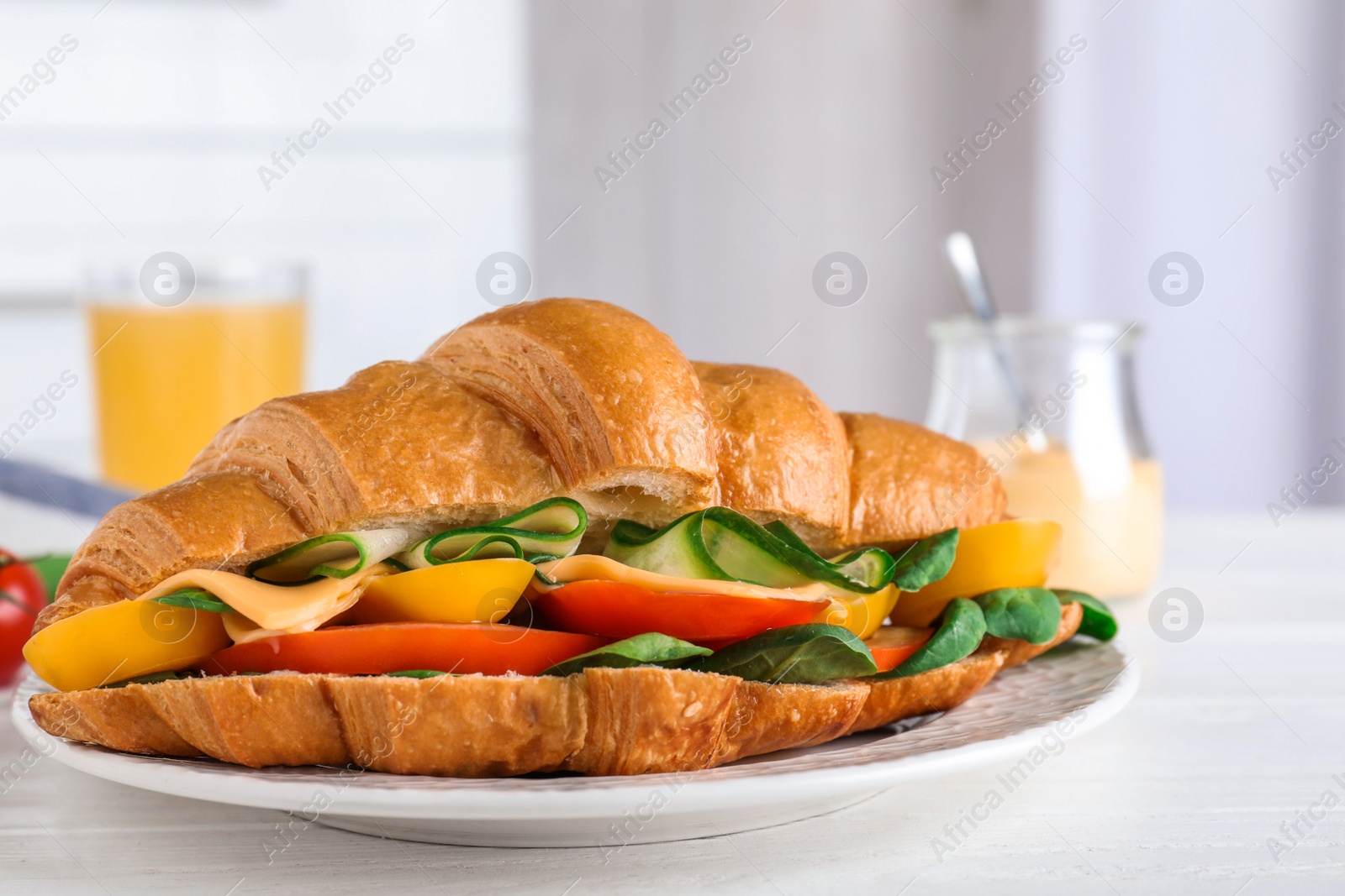 Photo of Tasty vegetarian croissant sandwich on white table, closeup