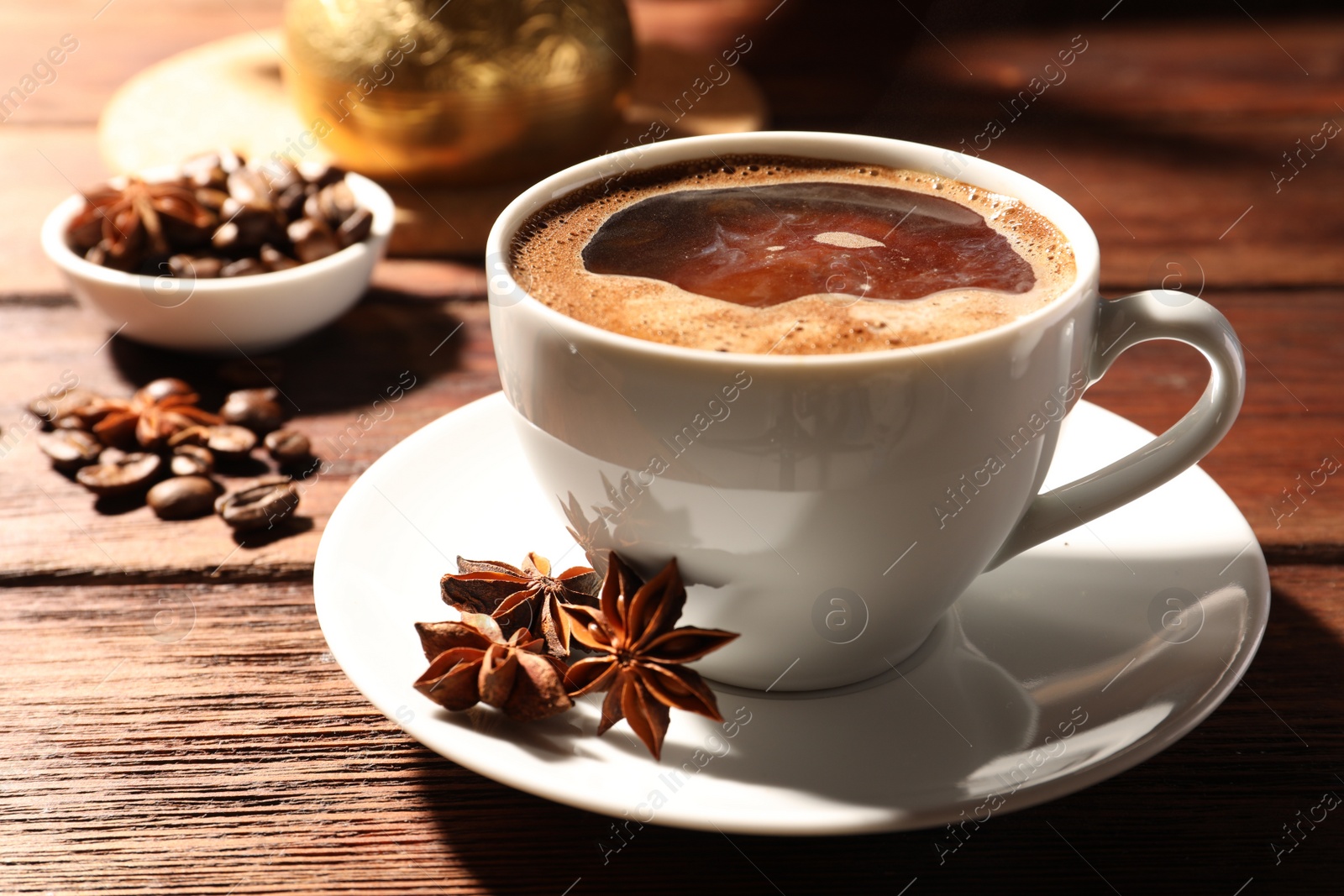 Photo of Aromatic hot coffee with milk anise stars on wooden table