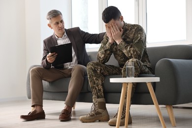 Professional psychotherapist working with military man in office