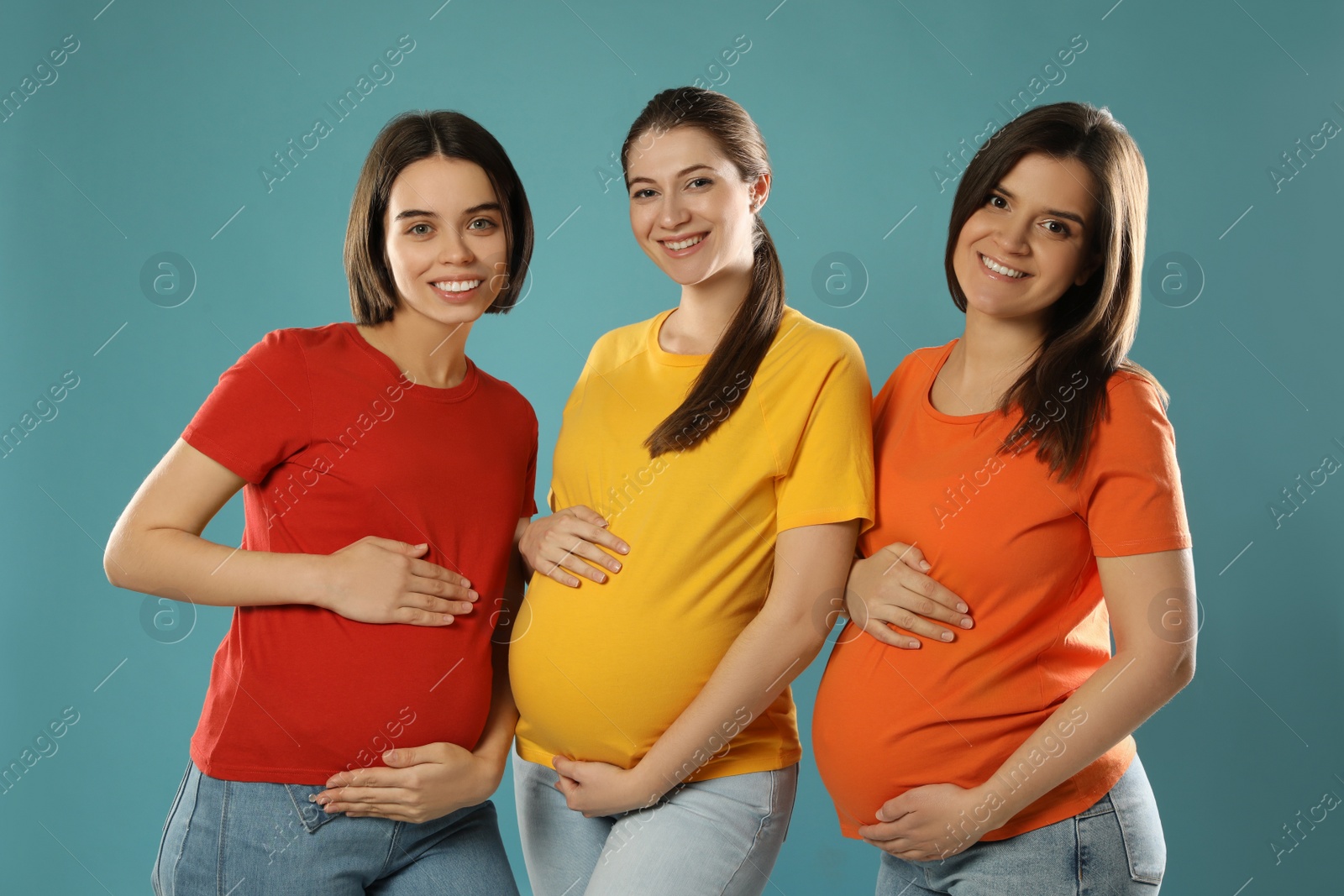 Photo of Happy young pregnant women on turquoise background