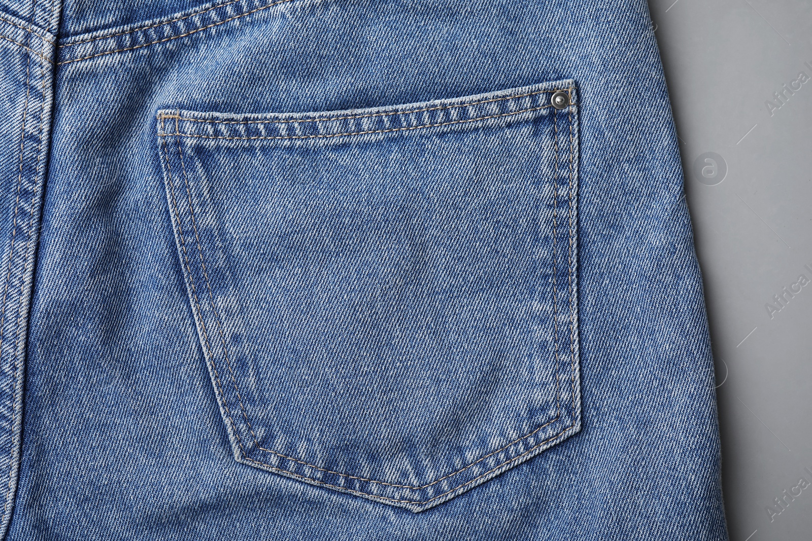 Photo of Jeans with pocket on grey background, top view