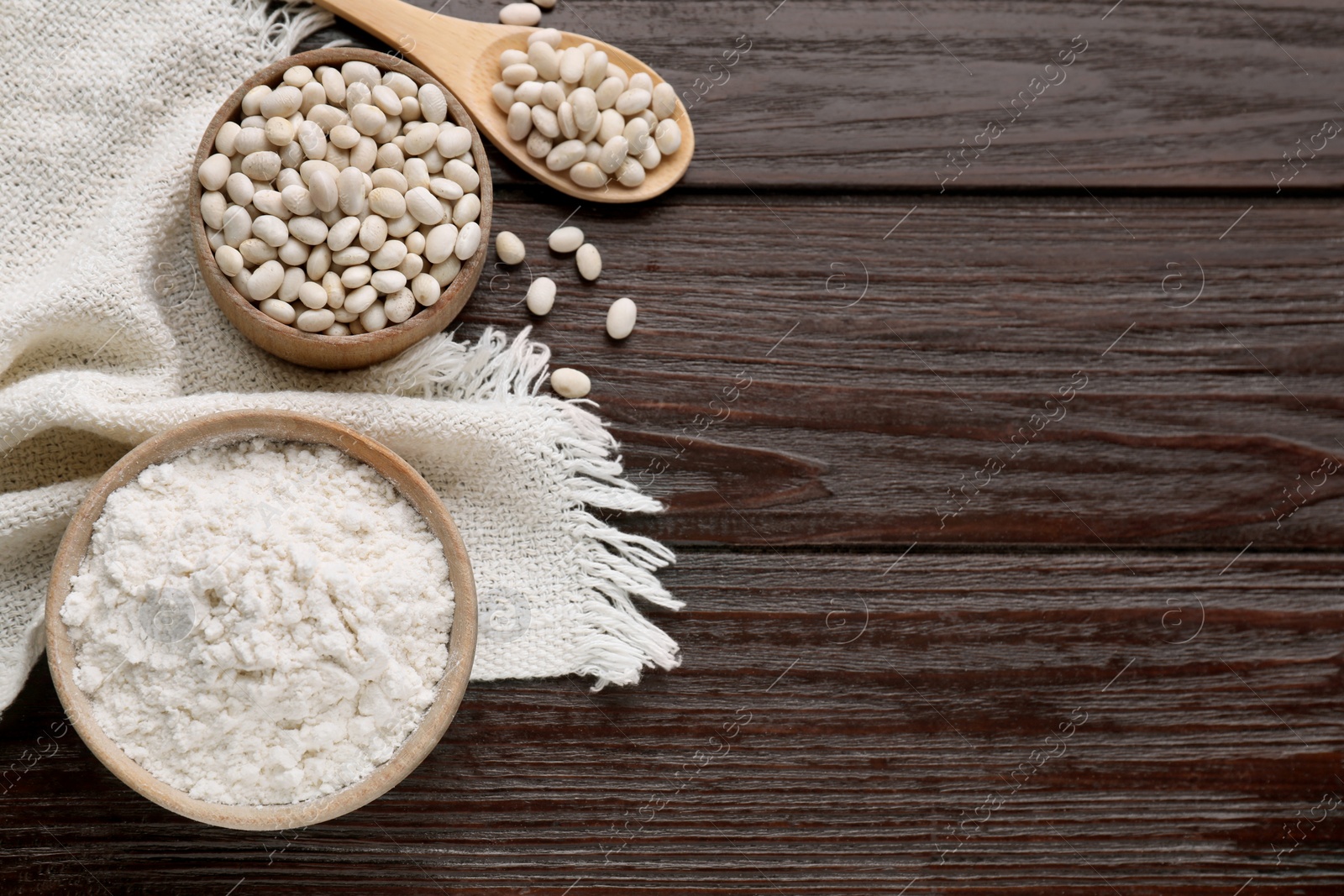 Photo of Kidney bean flour and seeds on wooden table, flat lay. Space for text