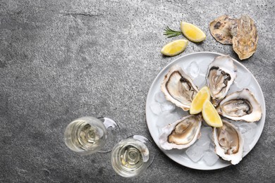 Photo of Fresh oysters with lemon, rosemary and glasses of champagne on grey table, flat lay. Space for text