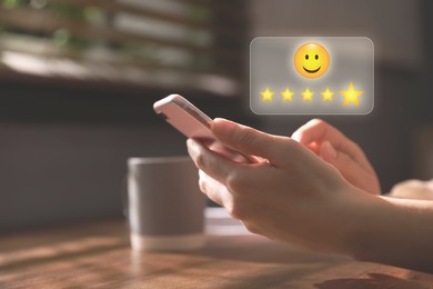 Woman leaving service feedback with smartphone at home, closeup. Stars and emoticon over device