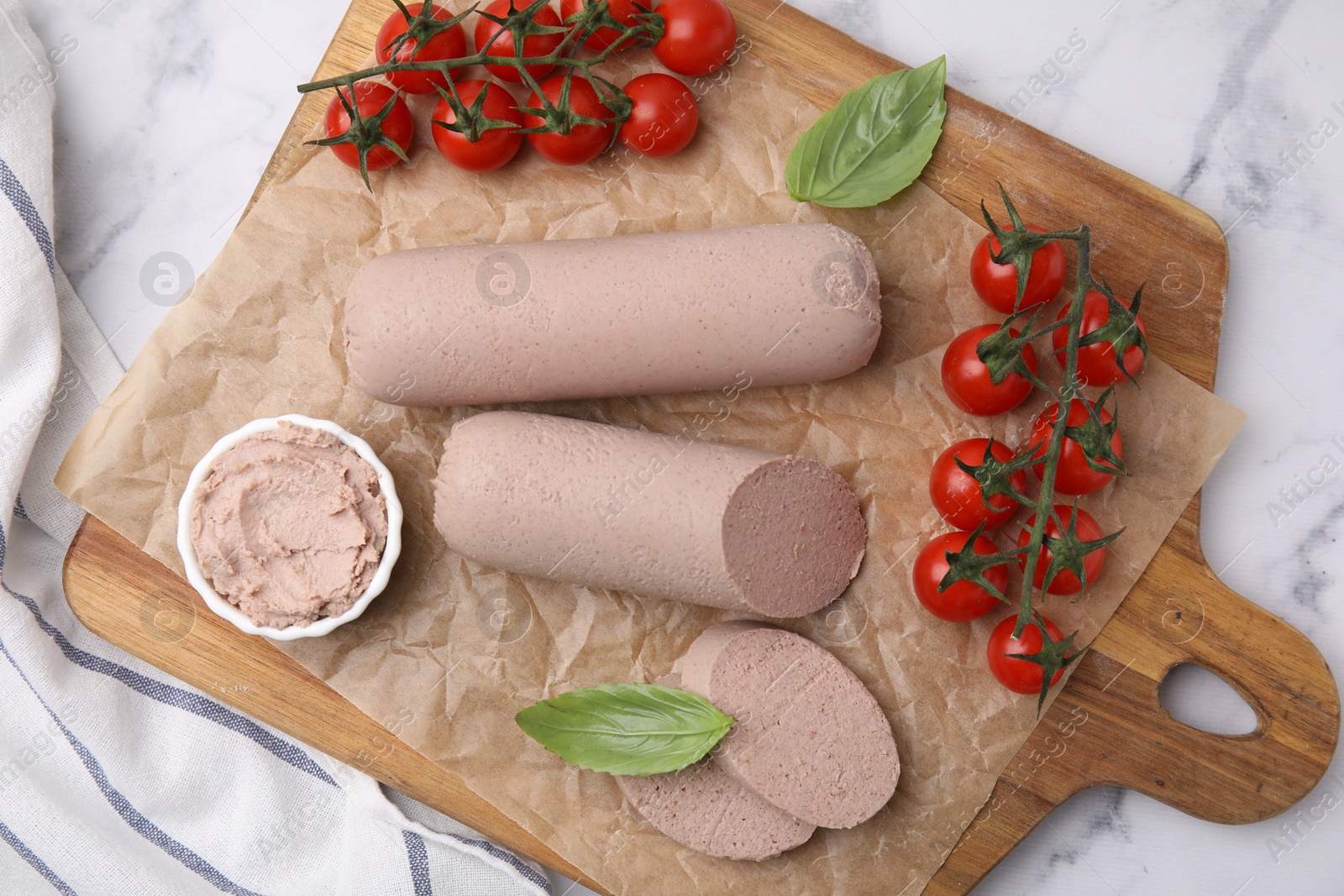 Photo of Delicious liver sausages, paste and cherry tomatoes on white marble table, top view