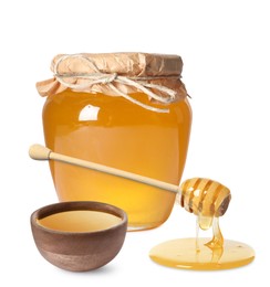 Natural honey dripping from dipper. Jar full of honey and bowl on white background