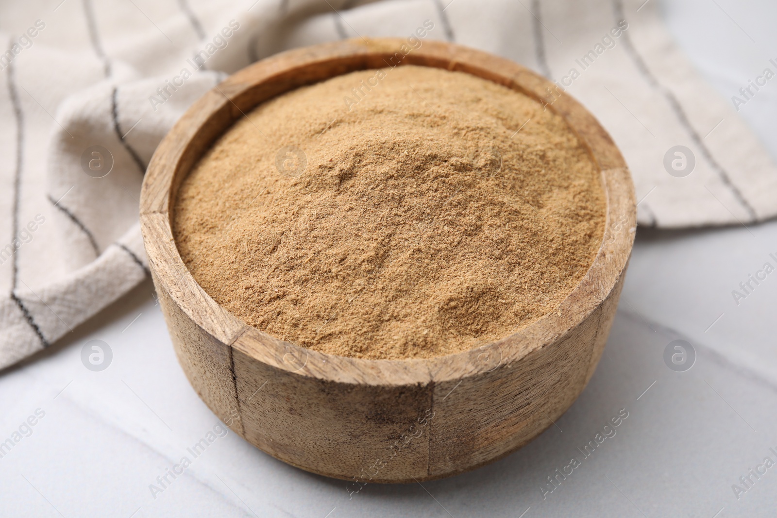 Photo of Dietary fiber. Psyllium husk powder in bowl on white table