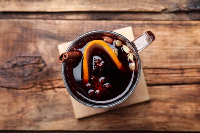 Photo of Aromatic mulled wine on wooden table, top view