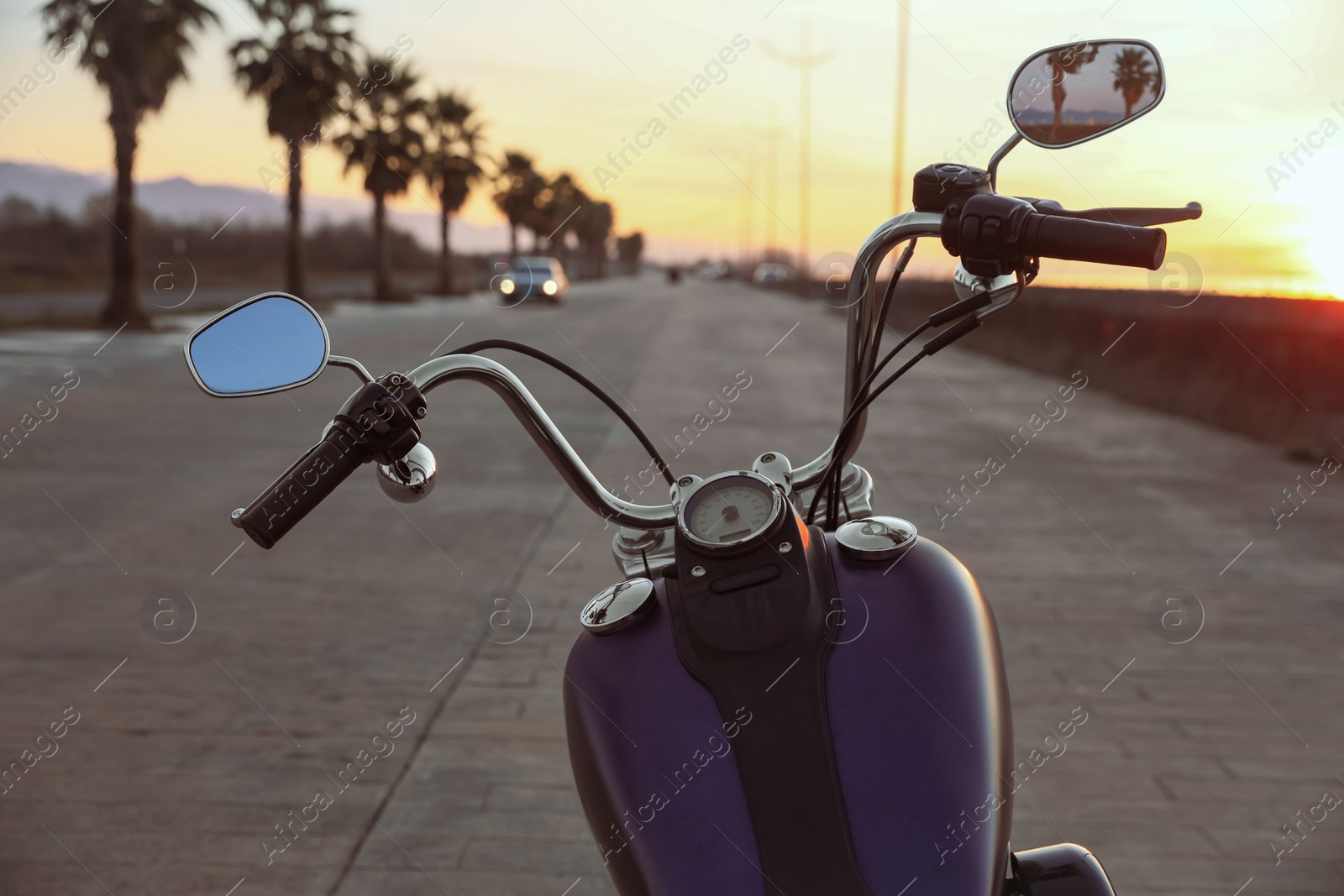 Photo of Modern black motorcycle on road at sunset