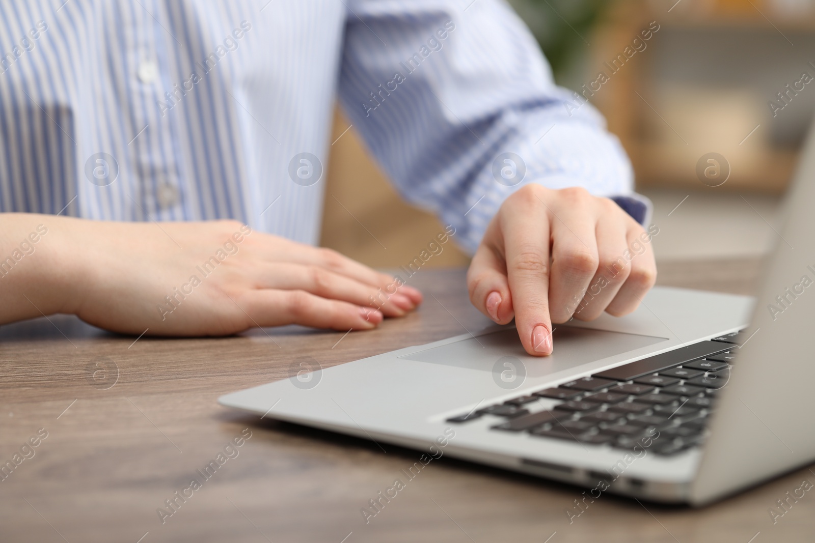 Photo of E-learning. Woman using laptop during online lesson at table indoors, closeup