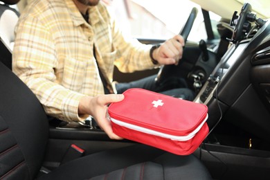 Photo of Man with first aid kit inside car, closeup