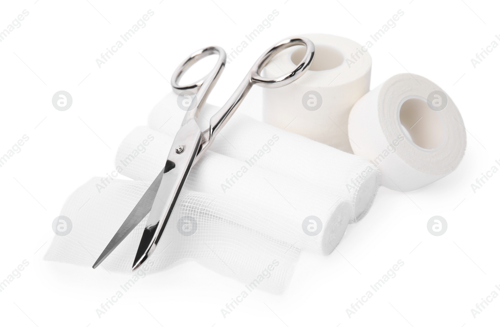 Photo of Medical bandage rolls, sticking plaster and scissors on white background